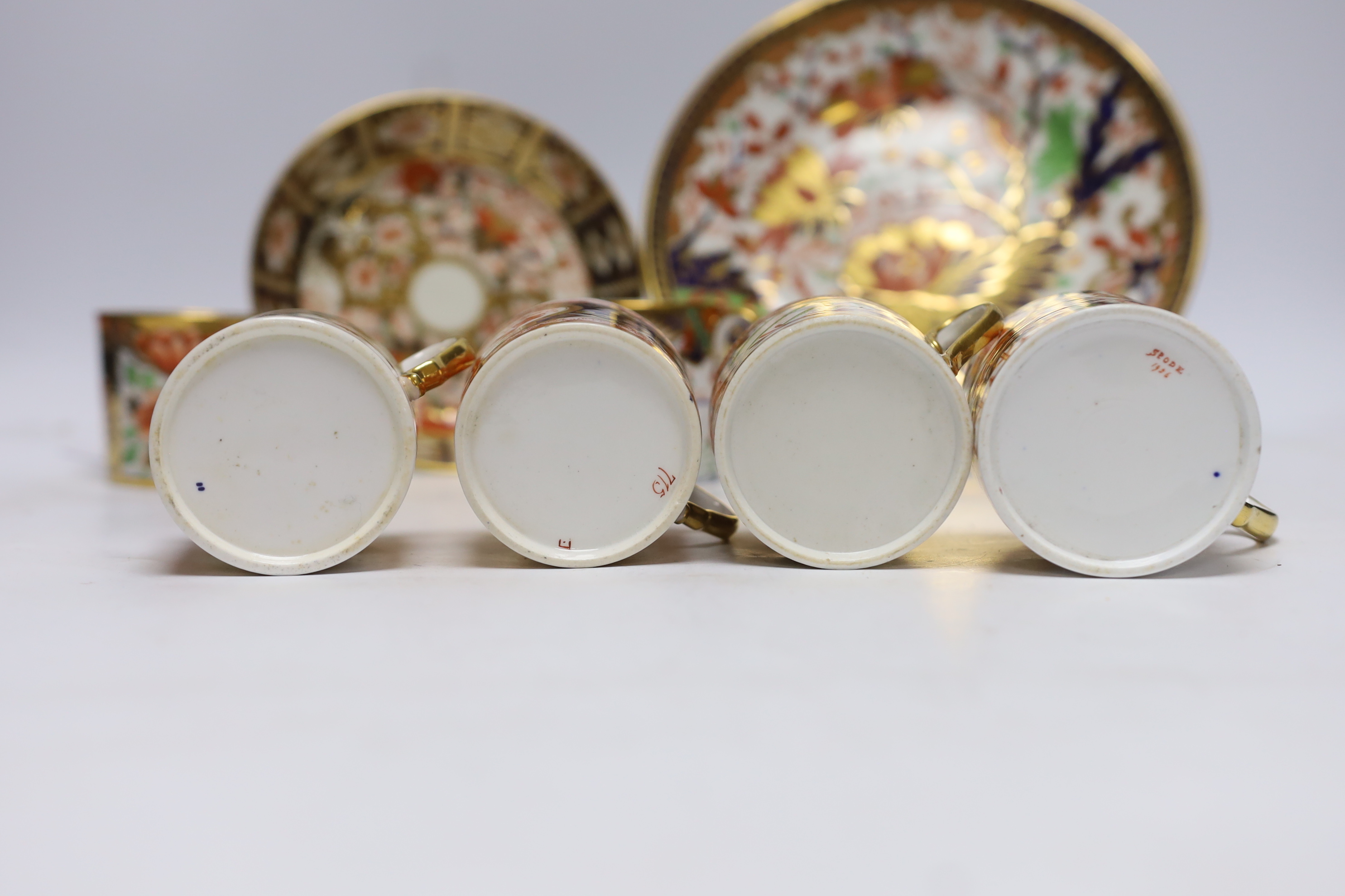 Ten 1800-1820 English porcelain coffee cans, including Imari pattern examples, one with matching saucer, together with a side plate (12)